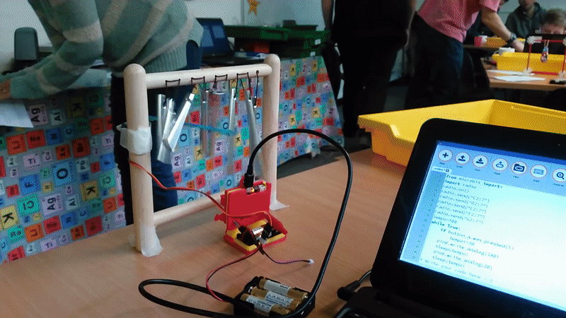 animated photo showing a servo motor ringing a windchime, the structure is make out of K'nex and the motor is secured with blue tack